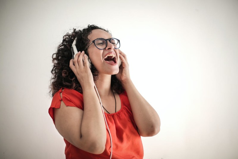 Mulher cantando com fones de ouvido